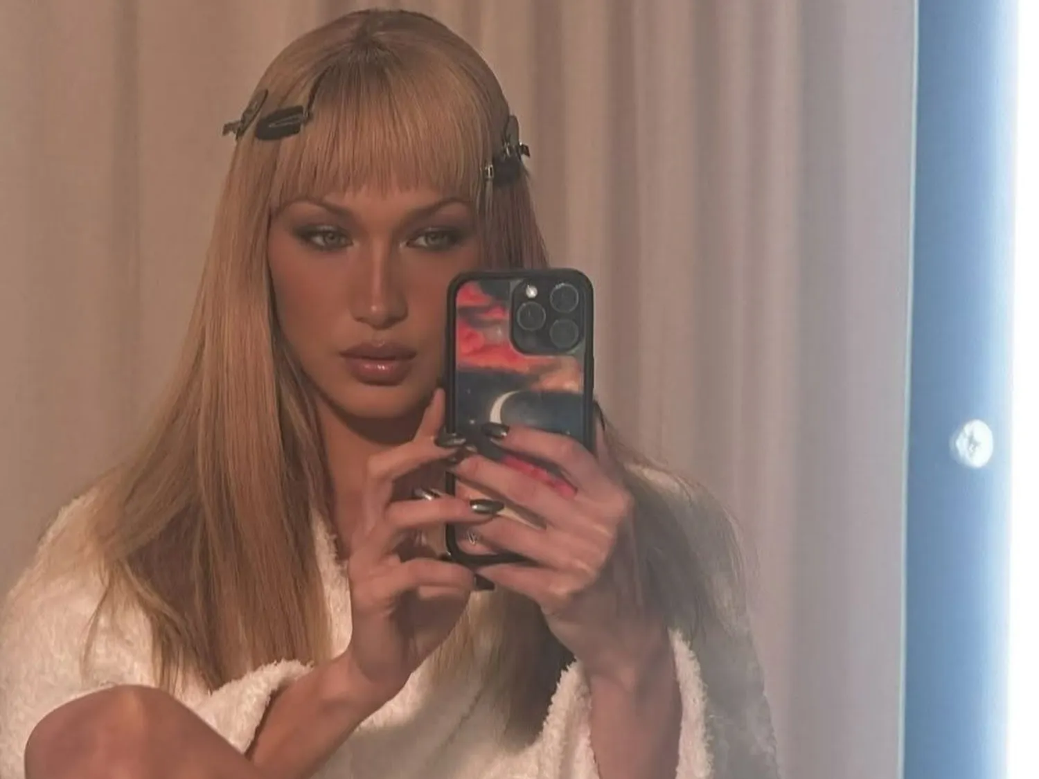 Bella Hadid with sharp, choppy blunt bangs and long dark hair.