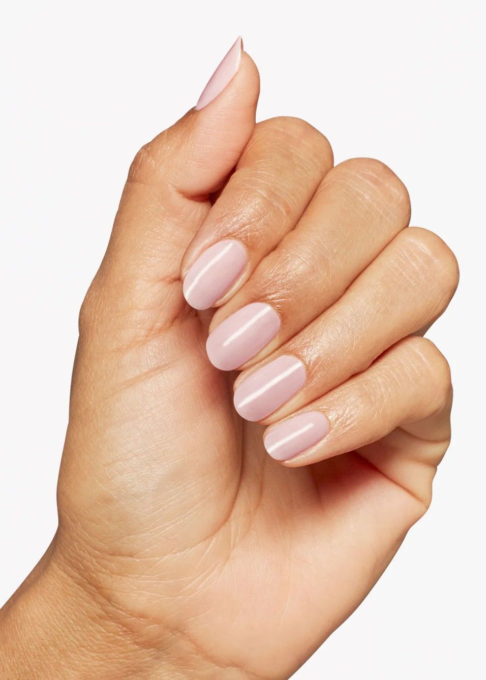 A close-up of a hand with a clean, light pink 'milky' manicure using OPI'm A Bubble Bunny.