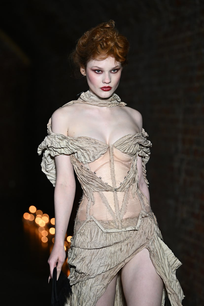 Theatrical makeup from Dreaming Eli FW 2026 with white-powdered skin and concentrated rouge.