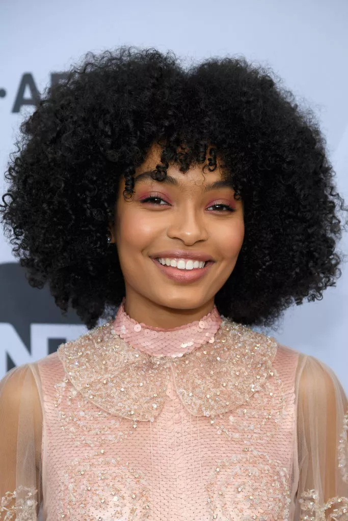 Yara Shahidi with a natural coily bob and curly bangs.