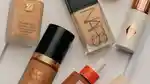 A wide-format editorial banner featuring various top-selling foundations from MECCA.