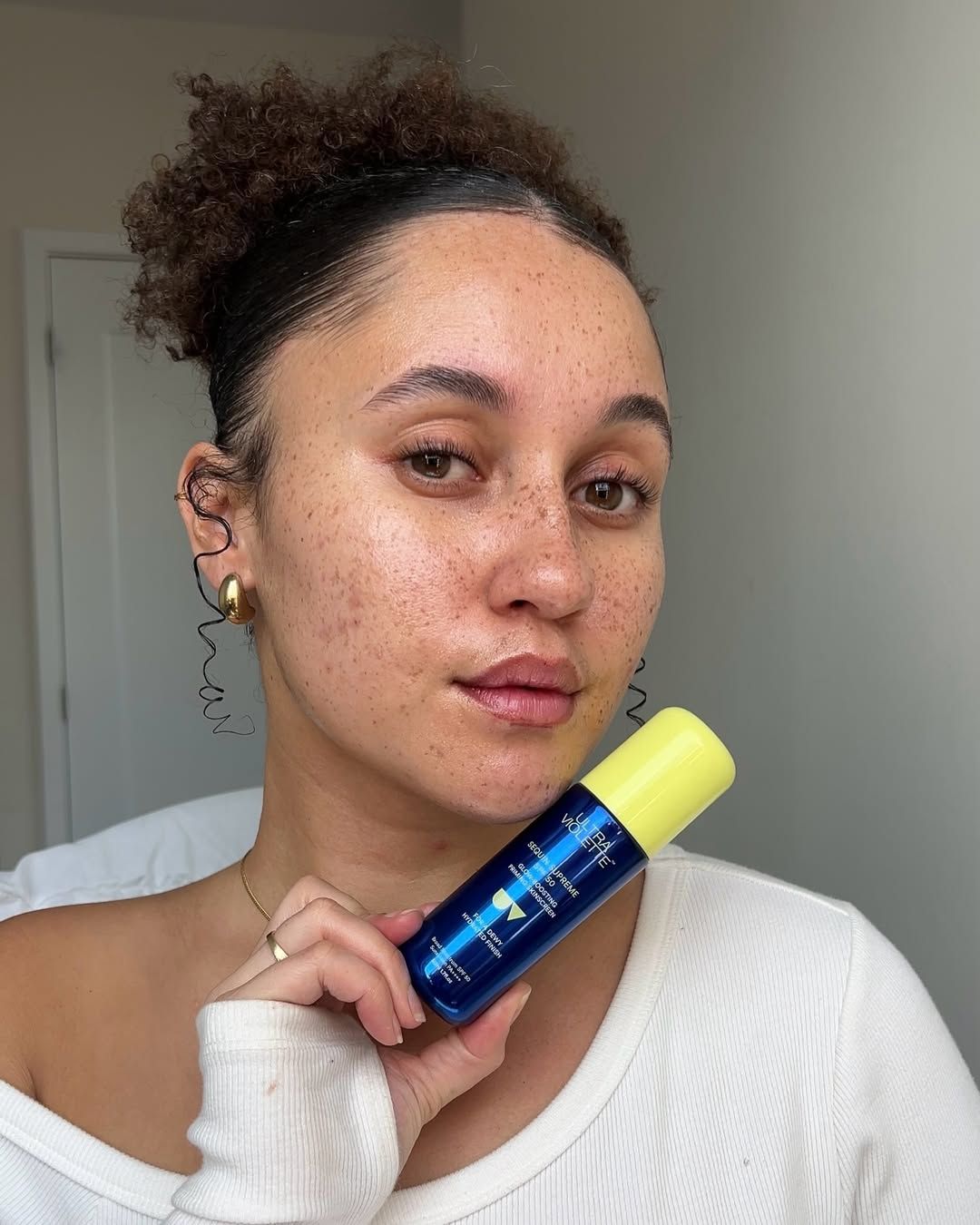 A model showing the radiant, dewy skin finish after applying the sunscreen.