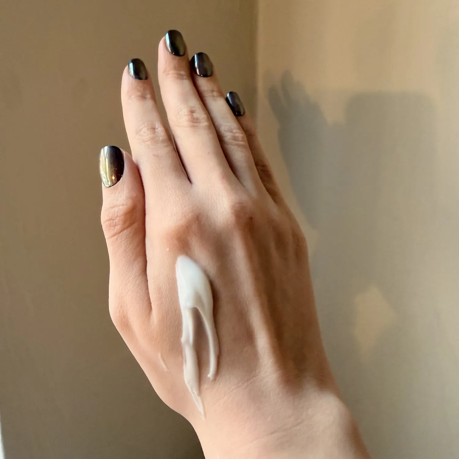 A close-up shot of the white, creamy texture of the Dewy Recovery Mask swatched on a hand.