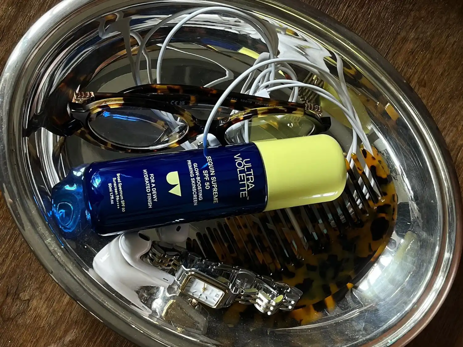 Ultra Violette sunscreen tube placed in a decorative silver dish with other objects.