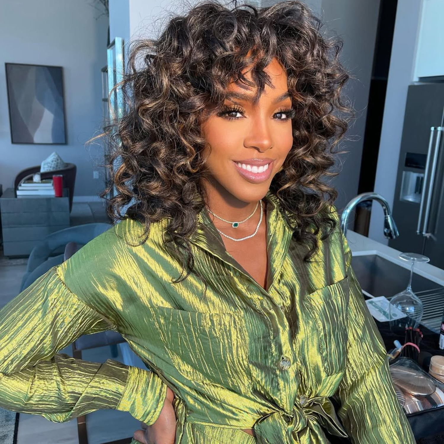 Kelly Rowland with soft curly bangs and a voluminous hairstyle.
